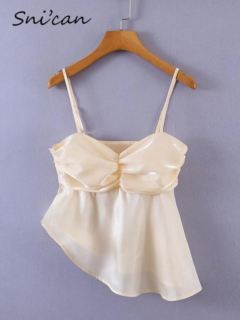 Beige Spaghetti Strap Blouse This blouse seems to combine elements of sophistication with a modern and trendy style, making it suitable for various occasions depending on how it's styled. Beige Spaghetti Strap Blouse with specific design features. Here's